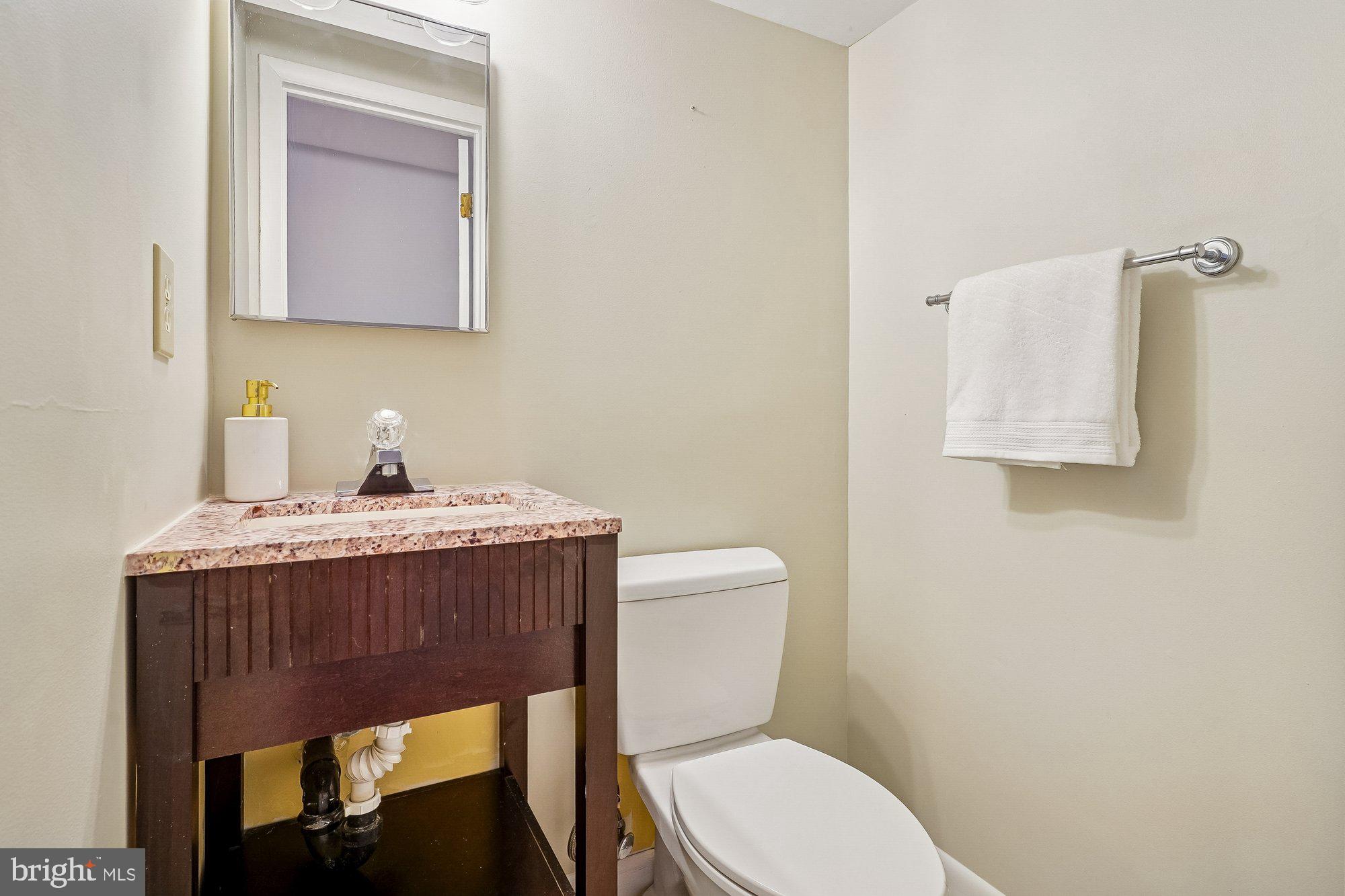 8826 Surveyors Place Springfield, VA 22152 - Photo 32 of 40 a bathroom with a toilet a sink and mirror
