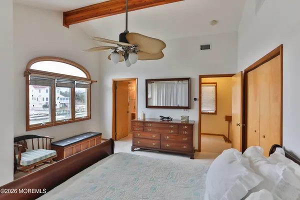 a spacious bedroom with a bed dresser and a window