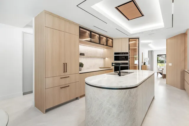 a bed sitting in a spacious bedroom next to a window