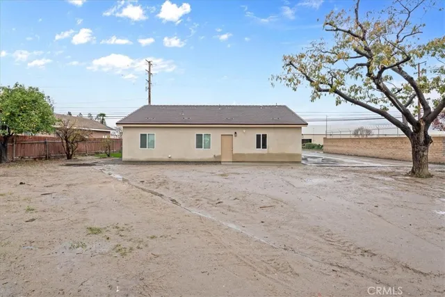 a front view of a house with a garden and trees