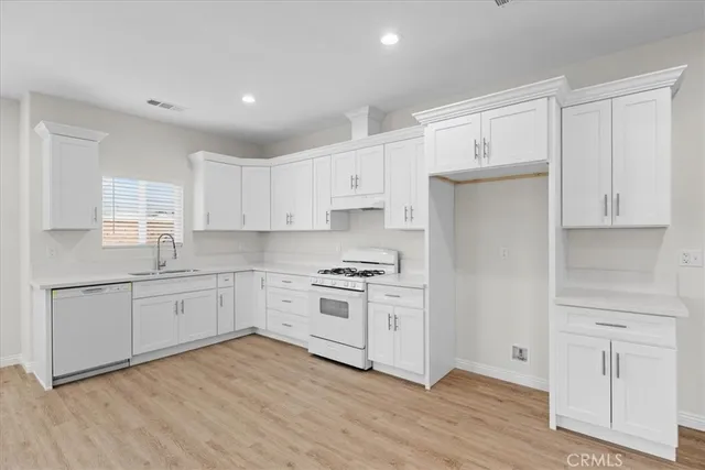 a kitchen with granite countertop white cabinets and white appliances