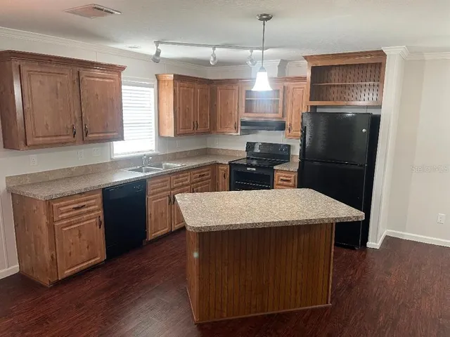 a kitchen with a sink a kitchen island and stainless steel appliances
