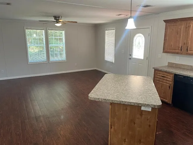 a kitchen with kitchen island a sink wooden floor and a large window