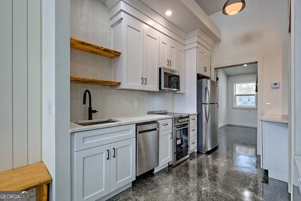 a kitchen with stainless steel appliances granite countertop a sink a stove and a refrigerator