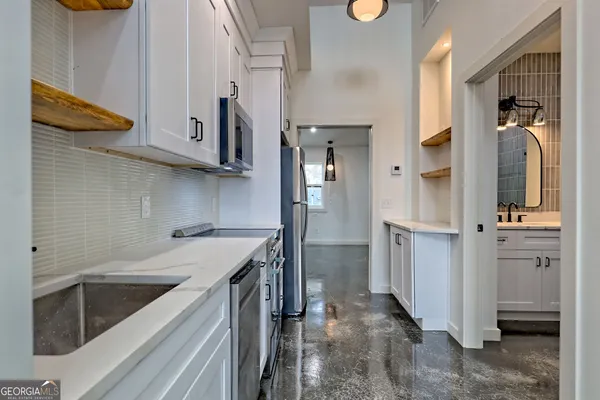 an empty room with windows and chandelier fan