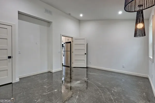 a hallway with a large mirror on a dresser with wooden floor