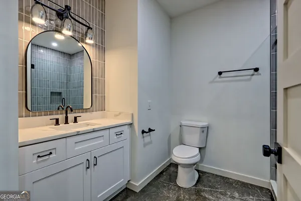 a bathroom with a granite countertop sink a mirror and shower