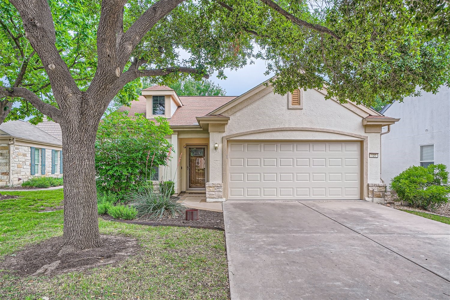 a front view of a house with a yard and a garage