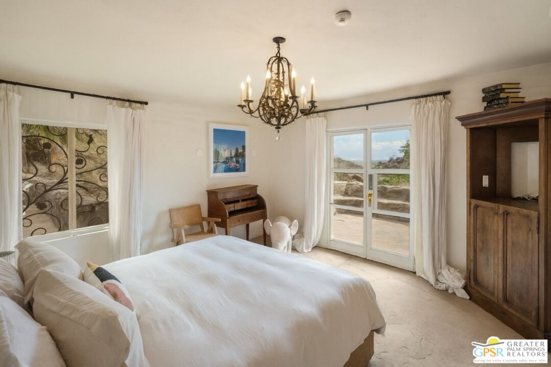 252 Ridge Road Palm Springs, CA 92264 - Photo 33 of 53 a bedroom with a bed and a chandelier