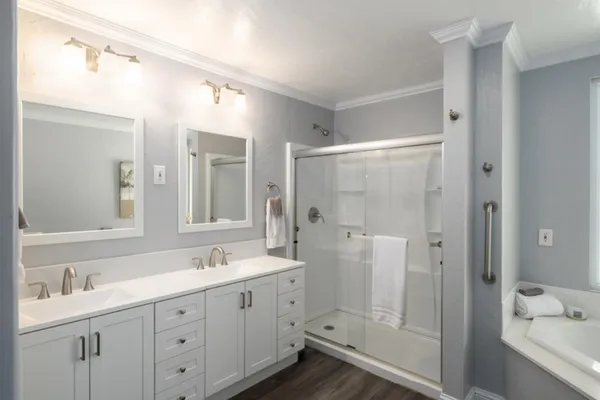 a bathroom with a shower tub double vanity sink and mirror
