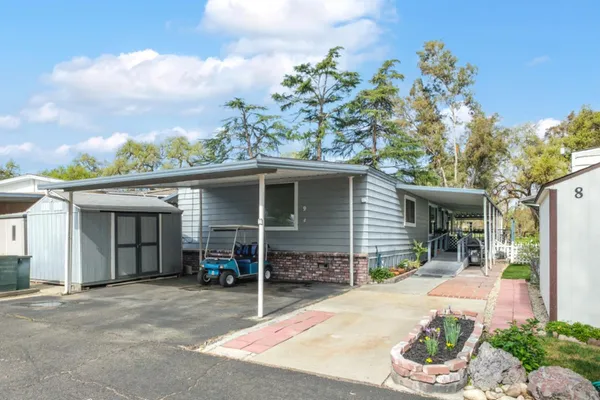 front view of a house with a yard and potted plants