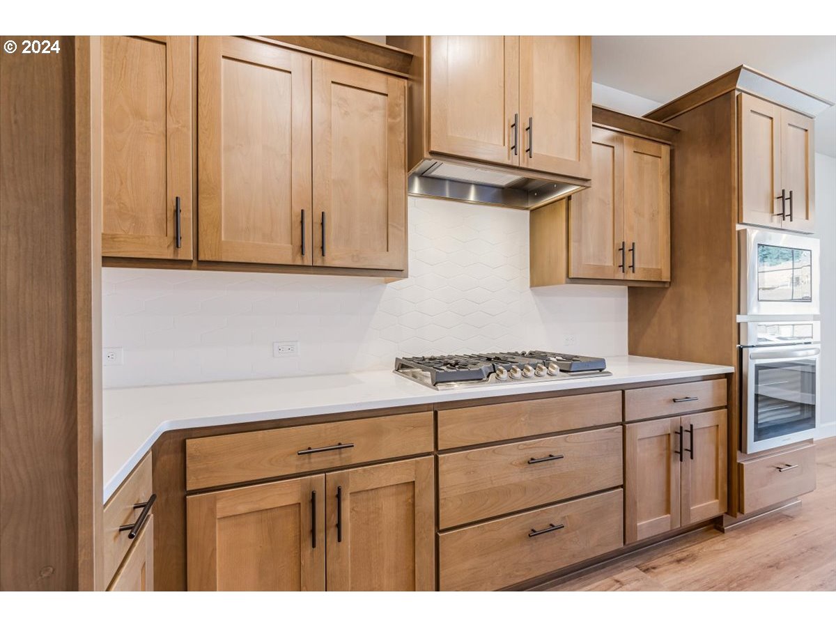 18050 Southwest Barrows Road Beaverton, OR 97007 - Photo 12 of 45 a kitchen with granite countertop cabinets stainless steel appliances and a counter space