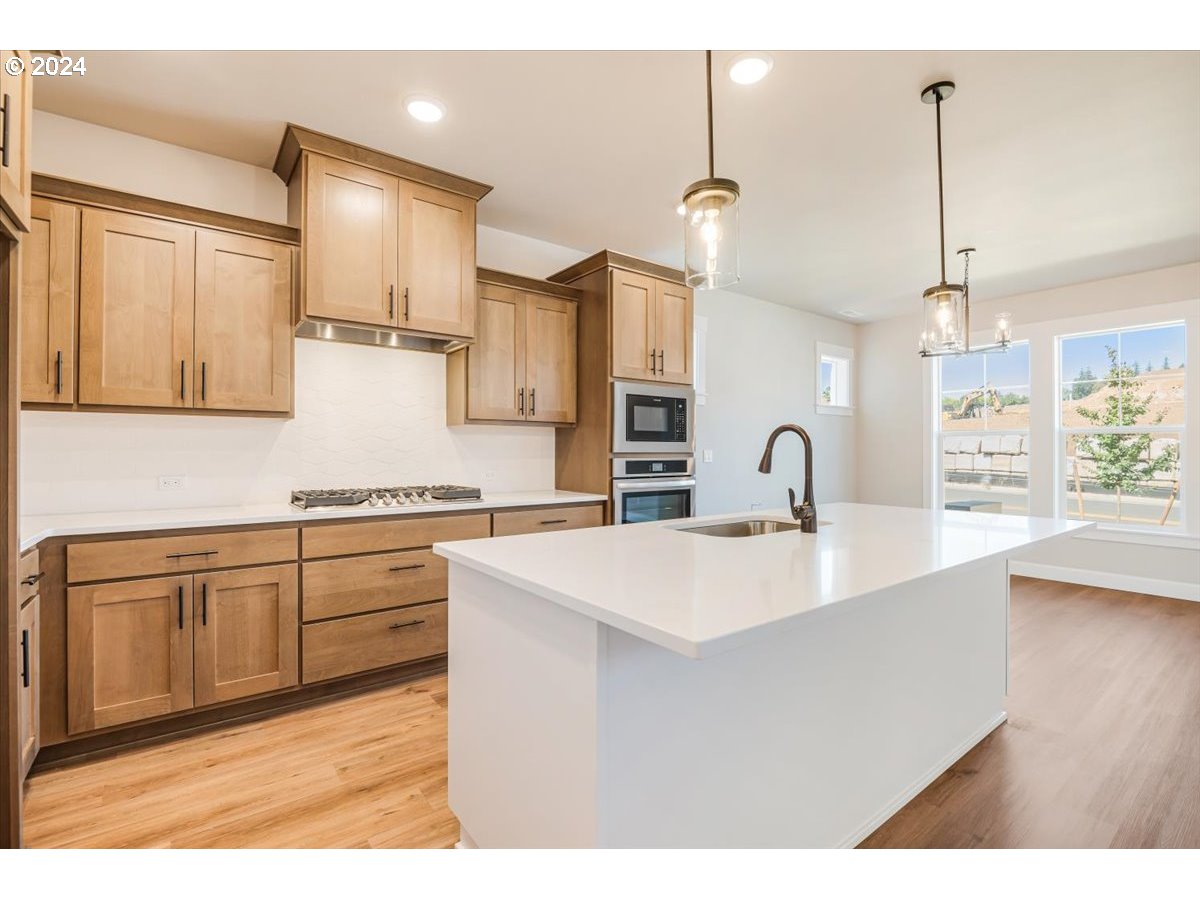 18050 Southwest Barrows Road Beaverton, OR 97007 - Photo 14 of 45 a large kitchen with kitchen island a sink stainless steel appliances and cabinets