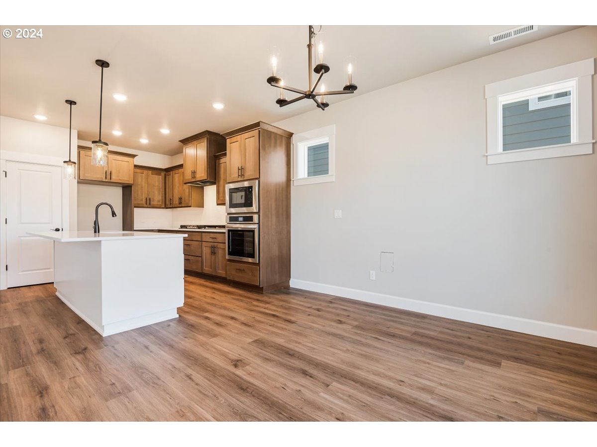 18050 Southwest Barrows Road Beaverton, OR 97007 - Photo 15 of 45 a view of kitchen with stainless steel appliances refrigerator stove and wooden floor