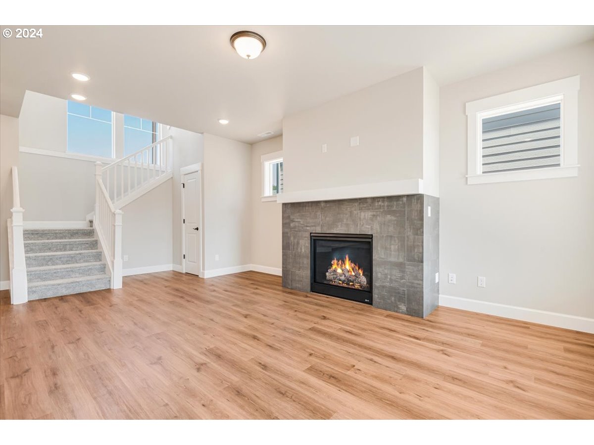 18050 Southwest Barrows Road Beaverton, OR 97007 - Photo 6 of 45 a view of an empty room with wooden floor fireplace and a window
