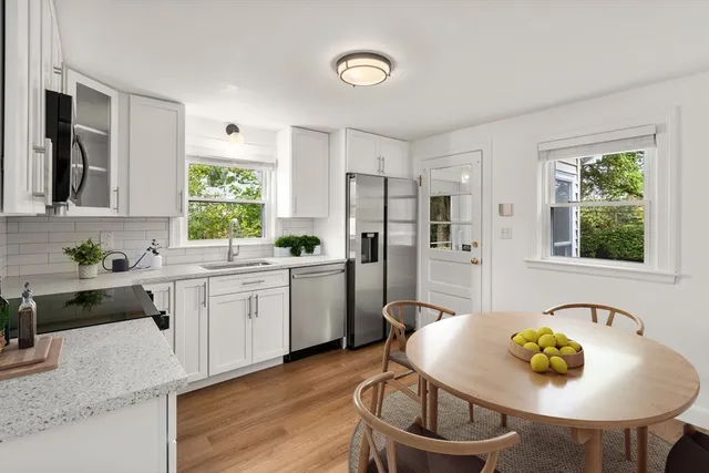 a kitchen with stainless steel appliances kitchen island a table and chairs in it