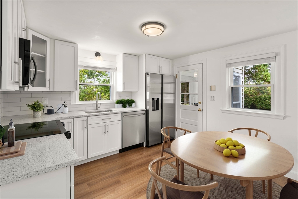 46 Bayard Street Dedham, MA 02026 - Photo 3 of 34 a kitchen with stainless steel appliances kitchen island a table and chairs in it