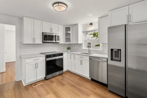 a kitchen with a sink stainless steel appliances and white cabinets