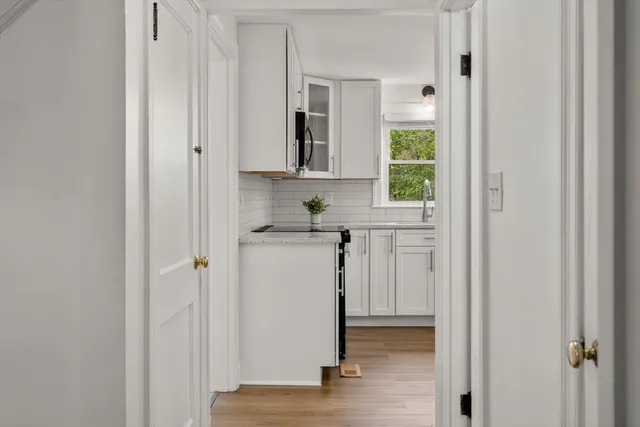 a view of a hallway with wooden floor and closet