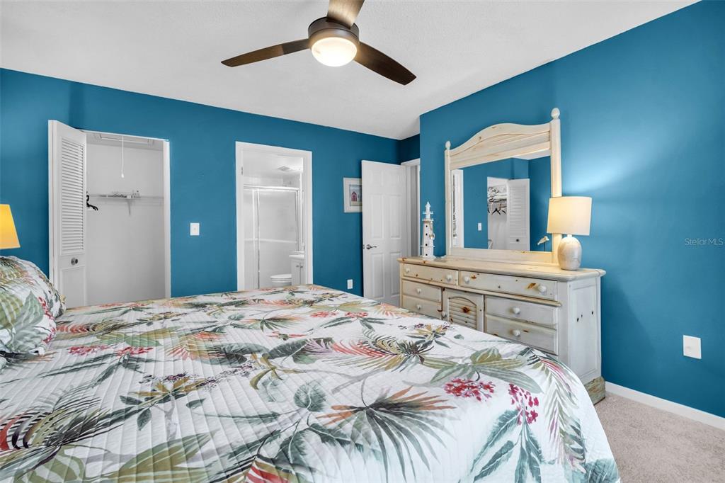2523 Pine Ridge Way South, Unit C2 Palm Harbor, FL 34684 - Photo 18 of 29 a bedroom with a bed and a chandelier