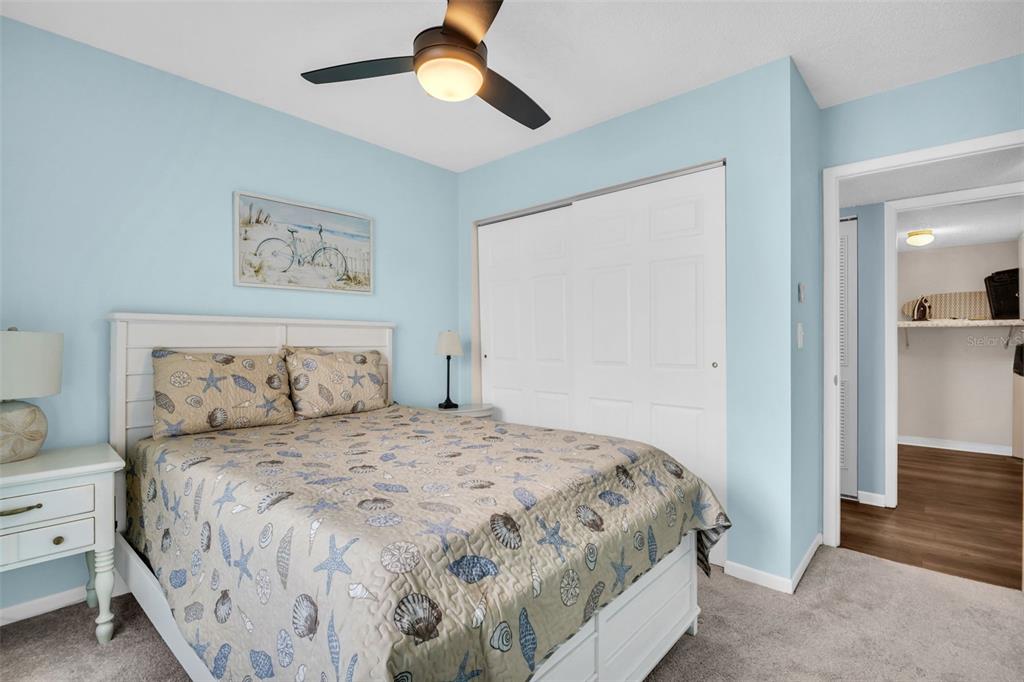 2523 Pine Ridge Way South, Unit C2 Palm Harbor, FL 34684 - Photo 22 of 29 a bedroom with a large bed and a chandelier