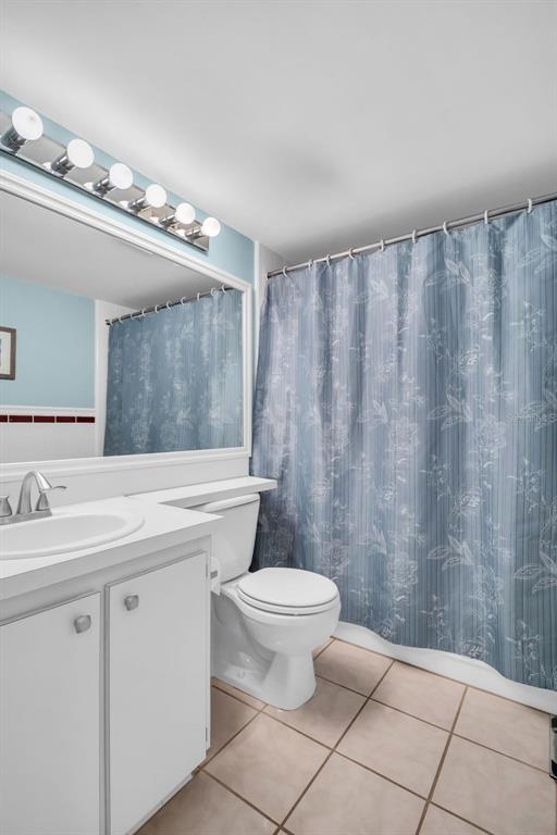 2523 Pine Ridge Way South, Unit C2 Palm Harbor, FL 34684 - Photo 24 of 29 a bathroom with a sink a toilet and mirror