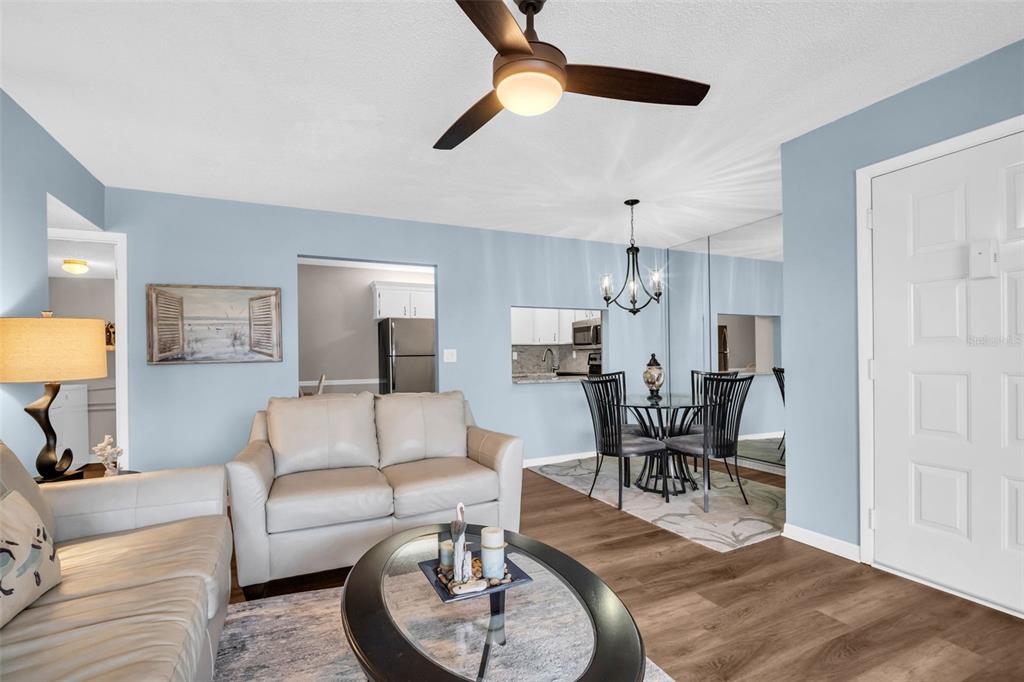 2523 Pine Ridge Way South, Unit C2 Palm Harbor, FL 34684 - Photo 8 of 29 a living room with furniture a dining table and a chandelier