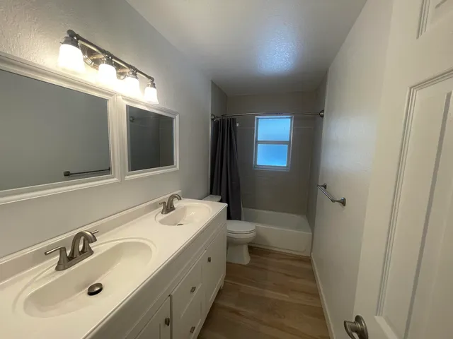 a bathroom with a sink and mirror with toilet