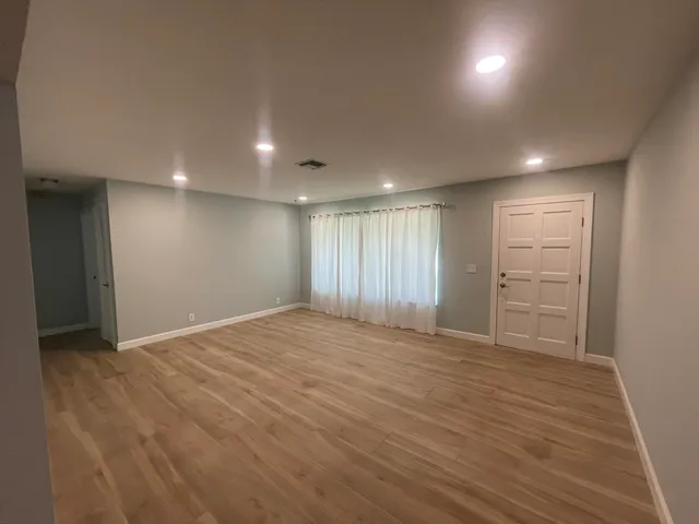 a view of an empty room with wooden floor