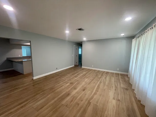 an empty room with wooden floor and entrance