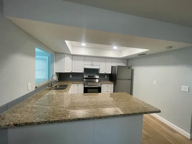 a kitchen with kitchen island a sink stove and refrigerator
