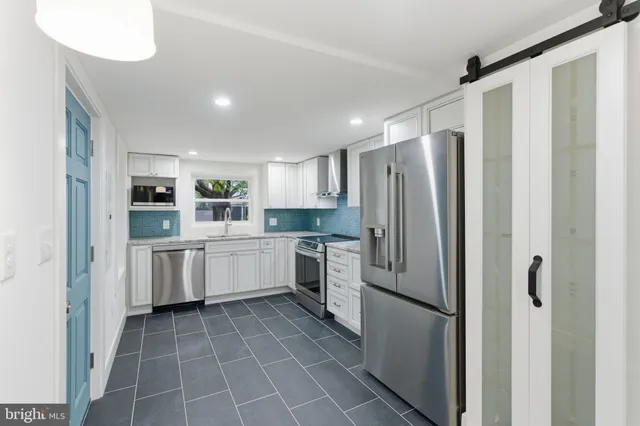 a kitchen with white cabinets stainless steel appliances and sink