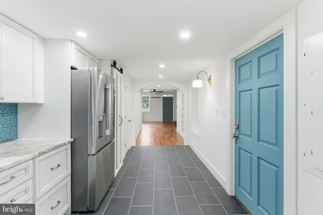 a kitchen with stainless steel appliances kitchen island granite countertop a refrigerator and a sink