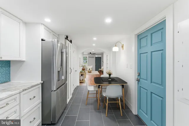 an empty room with wooden floor chandelier fan and windows