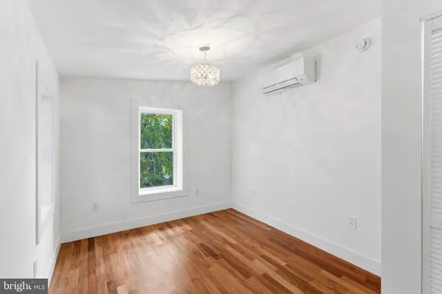 a view of a room with wooden floor exposed radiator and windows