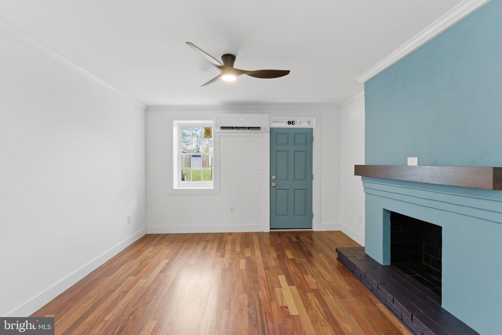 38 East 6th Street Frederick, MD 21701 - Photo 6 of 46 a view of empty room with wooden floor and fireplace
