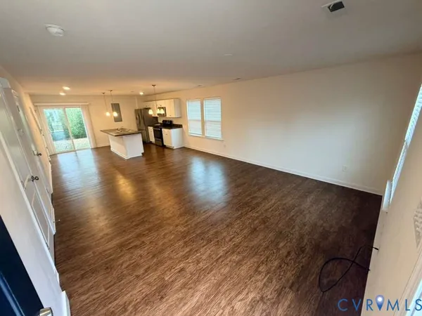 a view of empty room with wooden floor