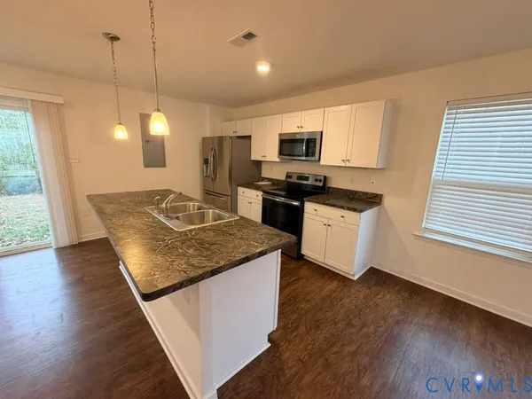 a kitchen with stainless steel appliances granite countertop a stove a sink and a microwave