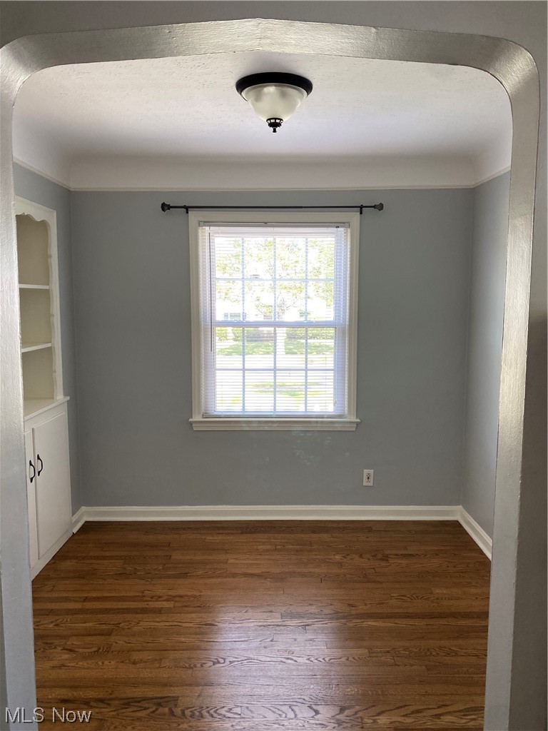 5680 Shawnee Road Cleveland, OH 44124 - Photo 5 of 21 Empty room featuring built in shelves and dark hardwood floors