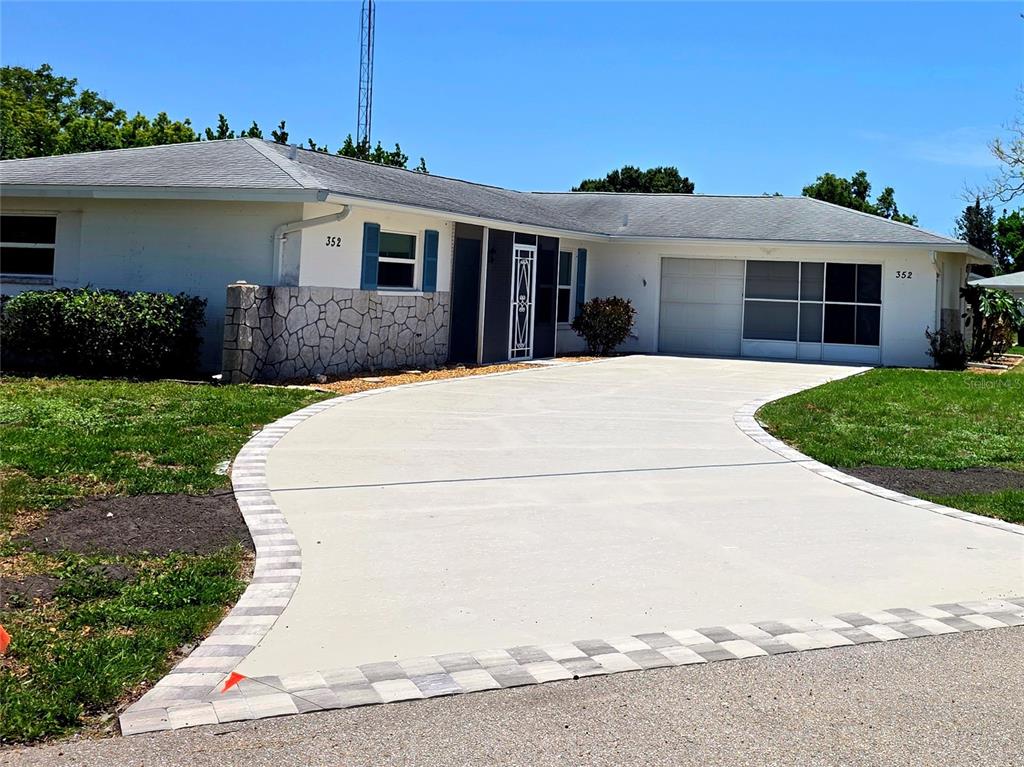 352 Pine Tree Road Venice, FL 34293 - Photo 3 of 25 a view of a white house with a small yard and potted plants