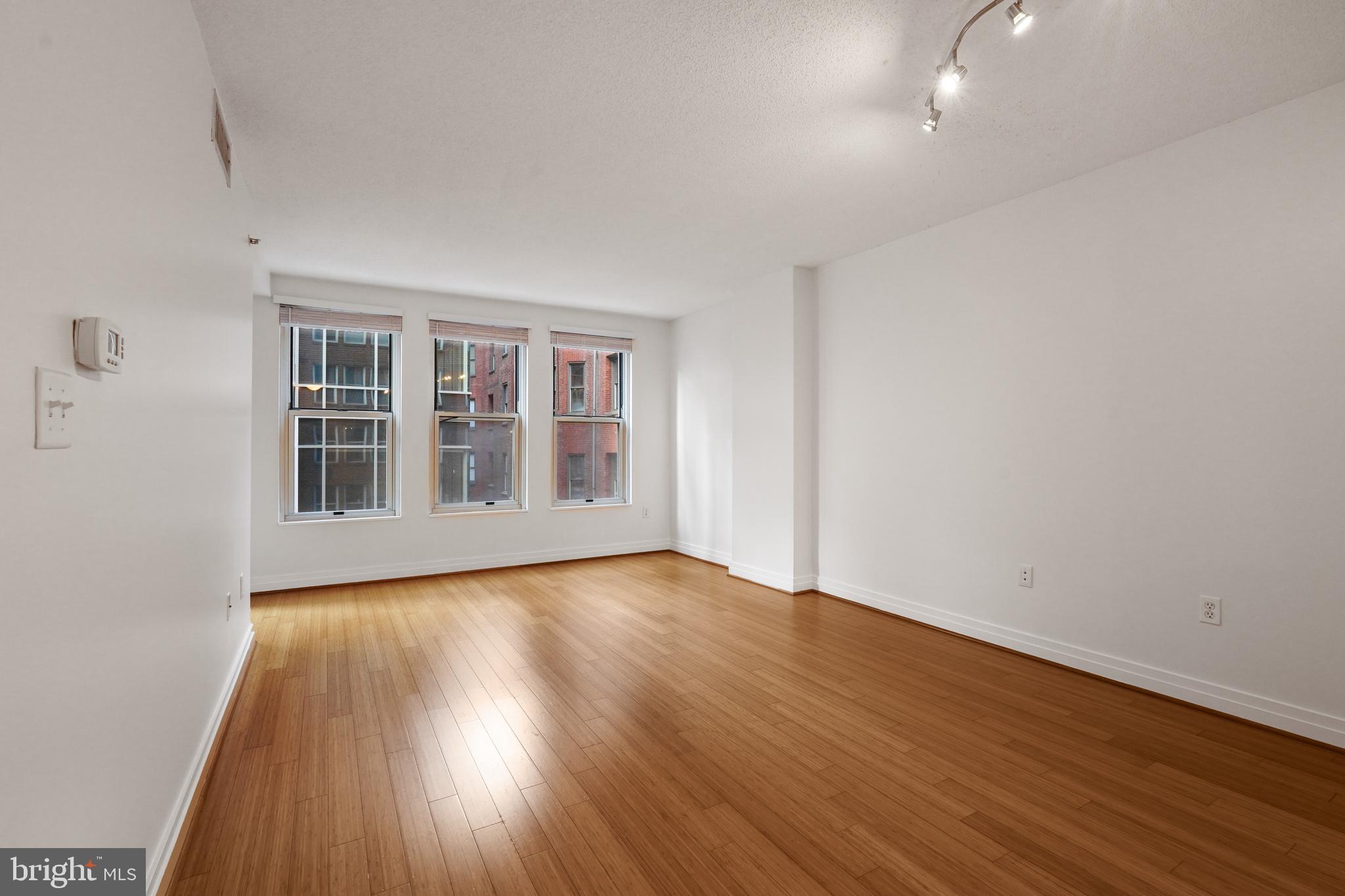 915 E Street Northwest, Unit 602 Washington, DC 20004 - Photo 6 of 23 a view of empty room with wooden floor and fan
