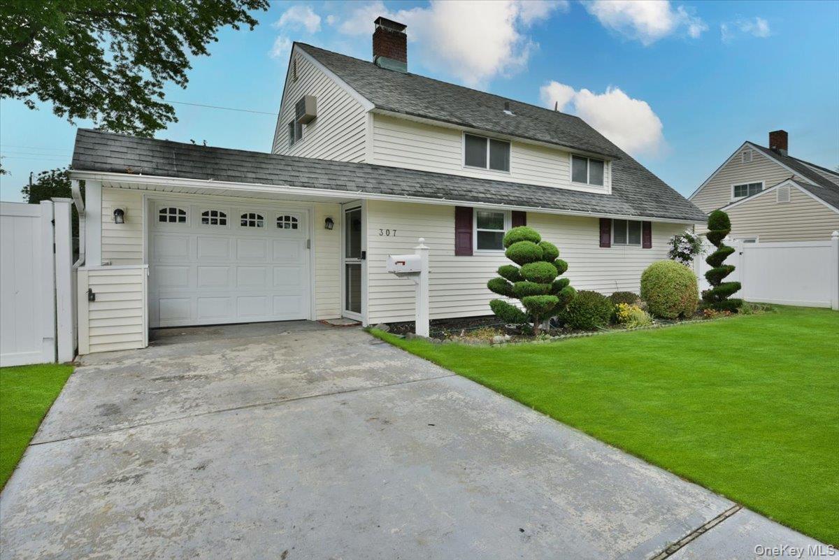 307 Blacksmith Road Levittown, NY 11756 - Photo 4 of 27 a front view of a house with a garden and plants