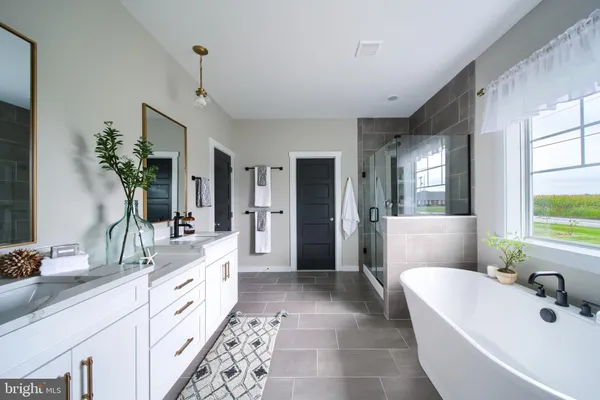 a spacious bathroom with a double vanity sink a large mirror and a bathtub