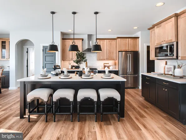 a kitchen with stainless steel appliances granite countertop a refrigerator a oven a sink with a dining table and chairs