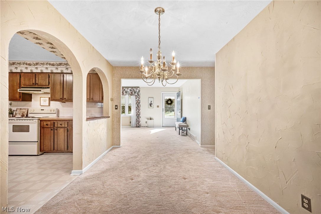 6452 Carsten Road Medina, OH 44256 - Photo 8 of 41 Hallway featuring light carpet and a chandelier