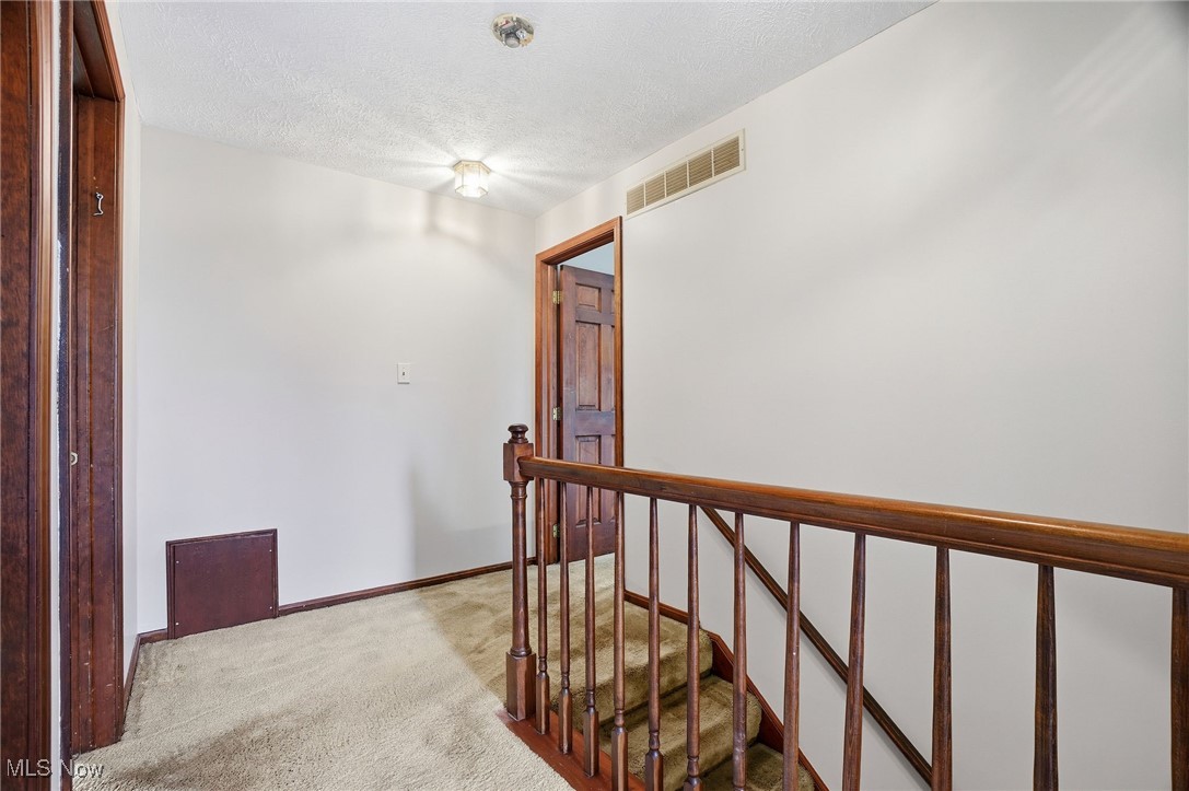 11710 Butternut Road Chardon, OH 44024 - Photo 36 of 48 Hall with an upstairs landing, a textured ceiling, and carpet floors