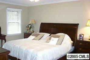 6639 Sharon Road Charlotte, NC 28210 - Photo 6 of 8 a bedroom with a bed and a window