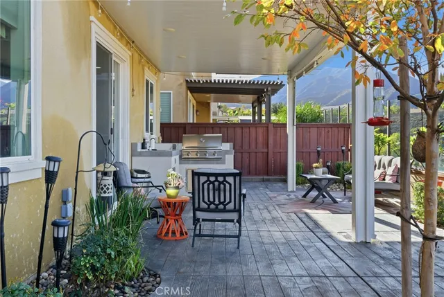 a view of a patio with table and chairs and a large tree