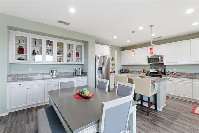 a kitchen with a dining table chairs and refrigerator