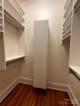 a view of a room with wooden floor and small window